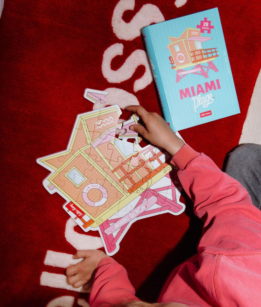 Puzzle coloré "Miami Plage" assemblé sur un tapis au sol avec la boîte à côté - vue du dessus - Hello Hossy