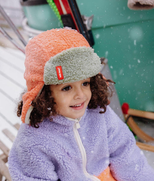 Fille portant la chapka en moumoute bicolore Cozy Jim - vue de 3/4 - Hello Hossy