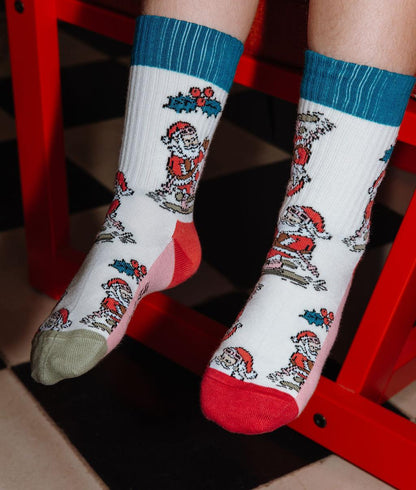 Paire de chaussettes imprimée Père Noël à ski, portée par un enfant – vue de 3/4 – Hello Hossy
