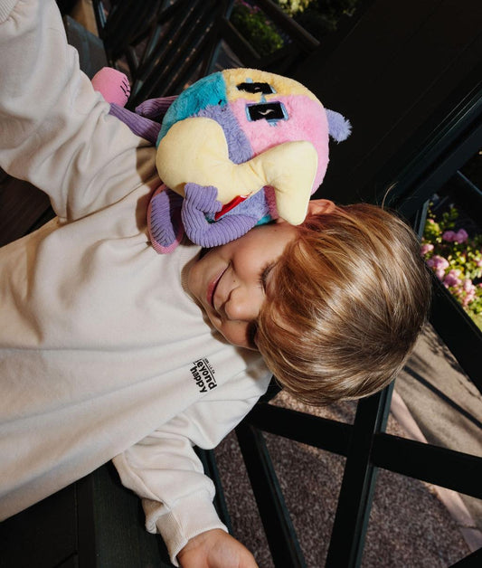 Enfant debout avec la peluche originale Disco Pop posée sur son épaule - photo lifestyle - Hello Hossy