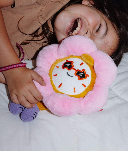 Enfant jouant avec la peluche originale Tic Tac Bloom allongée sur un lit - photo lifestyle - Hello Hossy