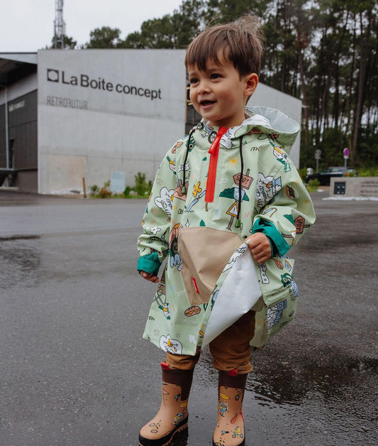 Garçon portant le poncho de pluie Mountain Ride - vue de 3/4 - photo lifestyle - Hello Hossy