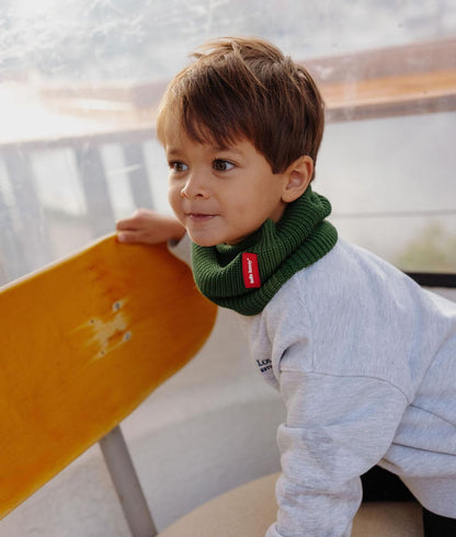Child wearing green ribbed-knit Snood with red label Hello Hossy