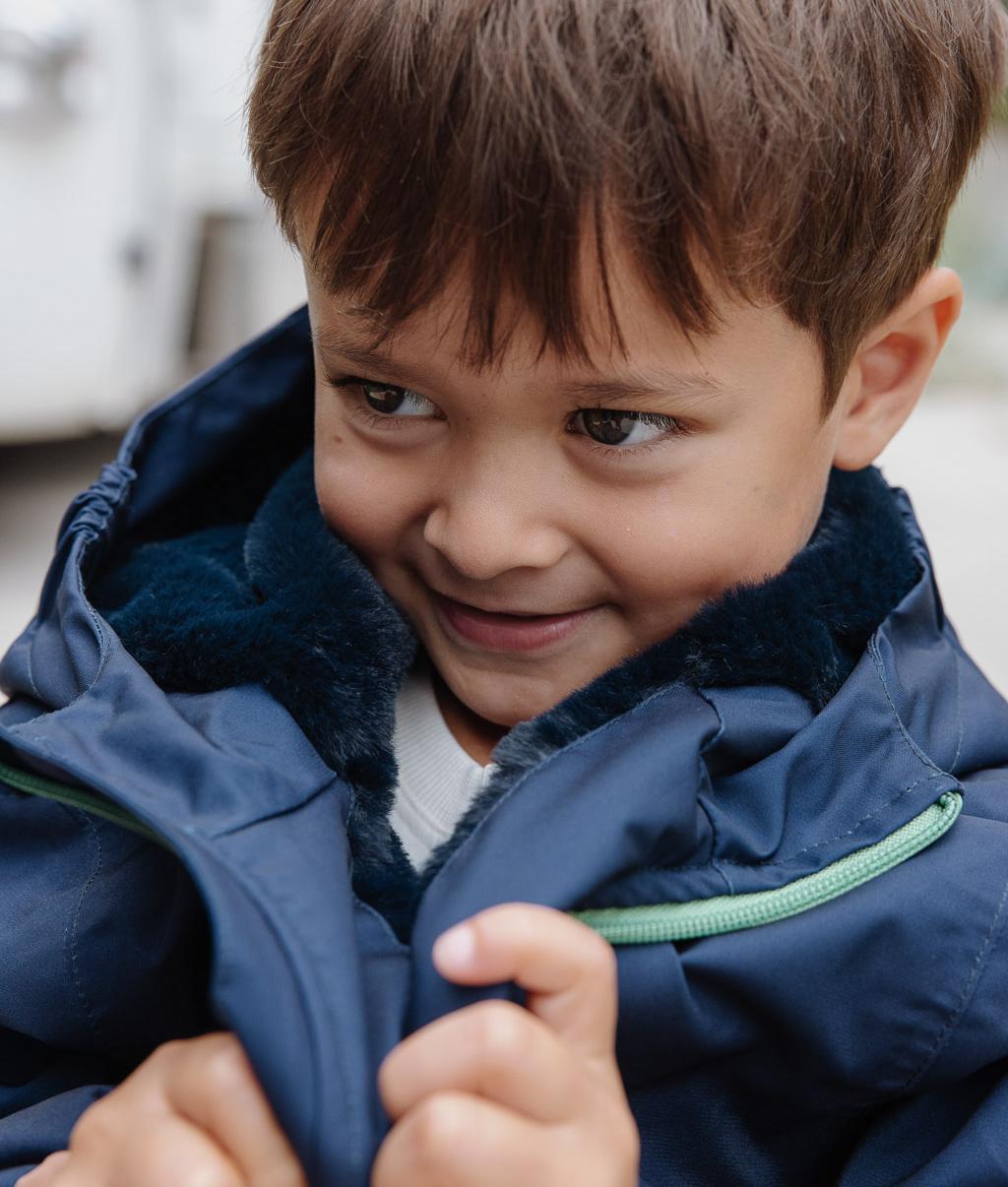 Child wearing blue winter jacket faux fur lining hood Hello Hossy
