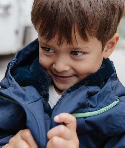 Child wearing blue winter jacket faux fur lining hood Hello Hossy