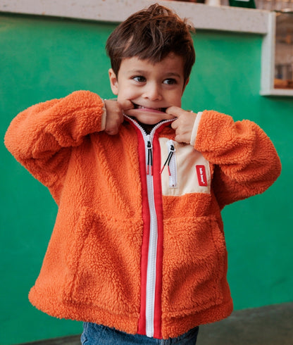 Child wearing Orange and Beige fleece jacket with zipped pocket Hello Hossy